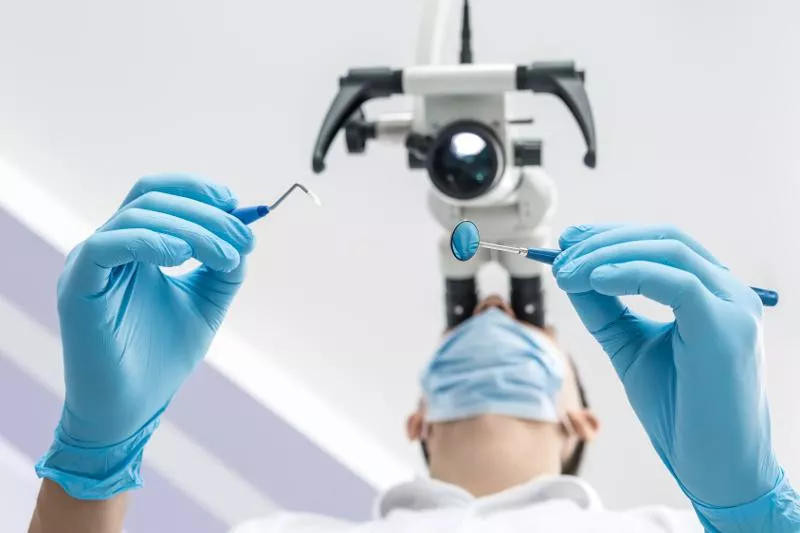 Dentysta patrzący przez mikroskop