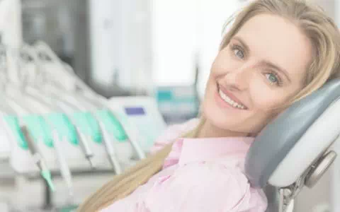 Uśmiechnięta kobieta podczas wizyty u dentysty
