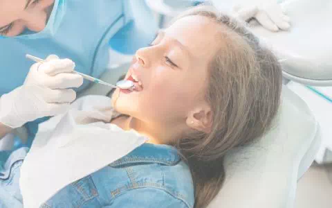 Dentystka sprawdzająca zęby dziecka
