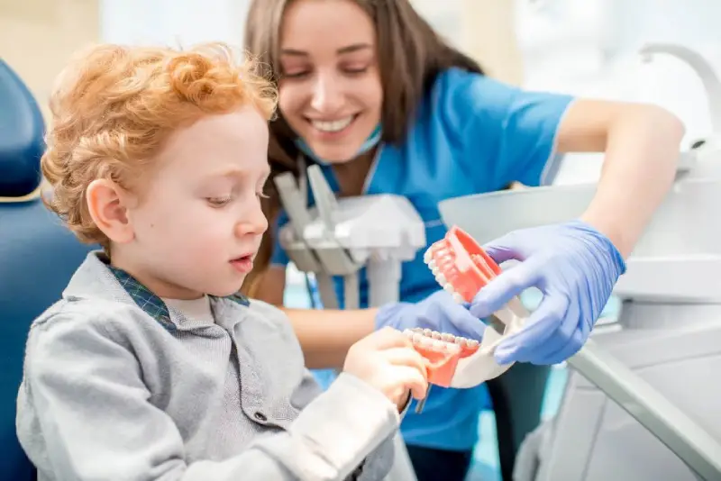 Dentystka pokazująca dziecku protezę